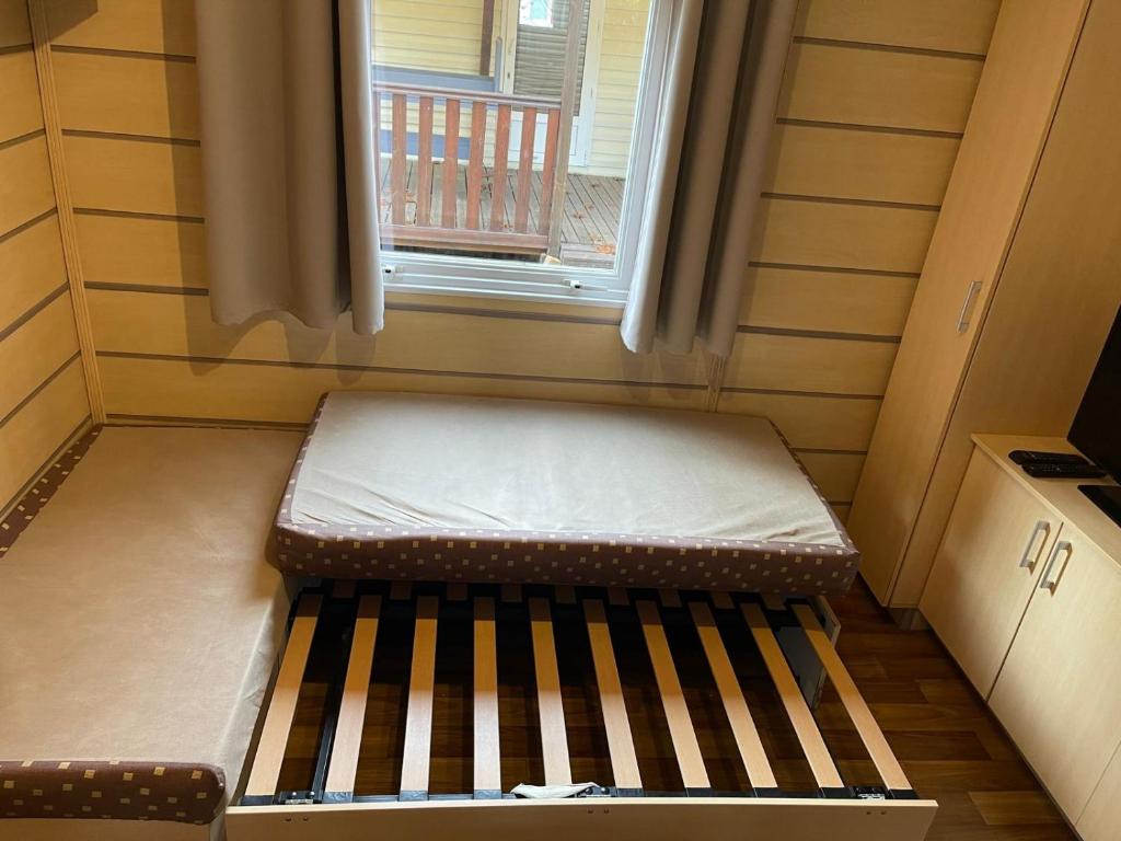 Ένα ή περισσότερα κρεβάτια σε δωμάτιο στο Bungalow camping la Berge fleurie