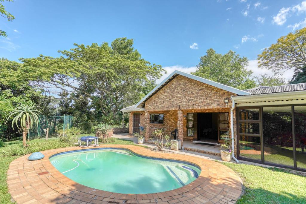 a swimming pool in a yard next to a house at Winston Manor in Gillitts