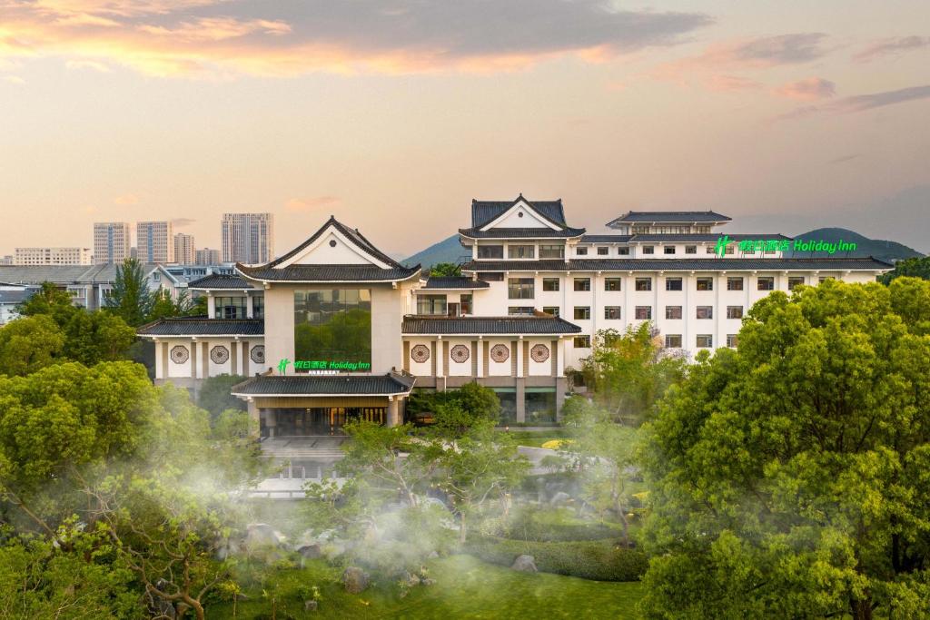 a building with a garden in front of it at Holiday Inn Xuzhou Yunquan by IHG in Xuzhou