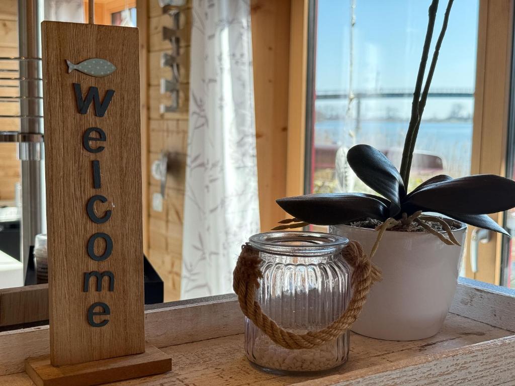 a plant in a jar next to a wooden sign at Haus Sina in Wangerland
