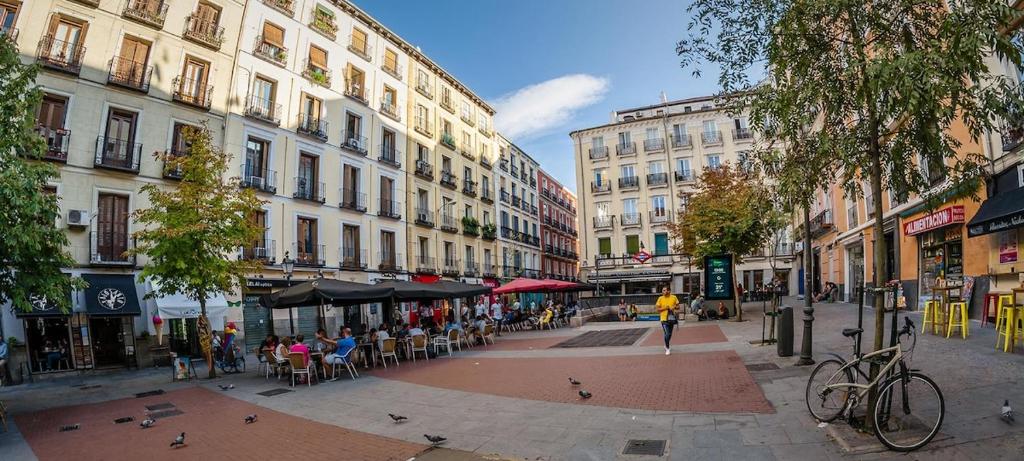 a city street with tables and chairs and buildings at Buhardilla en Chueca, a pasos de Gran Vía in Madrid