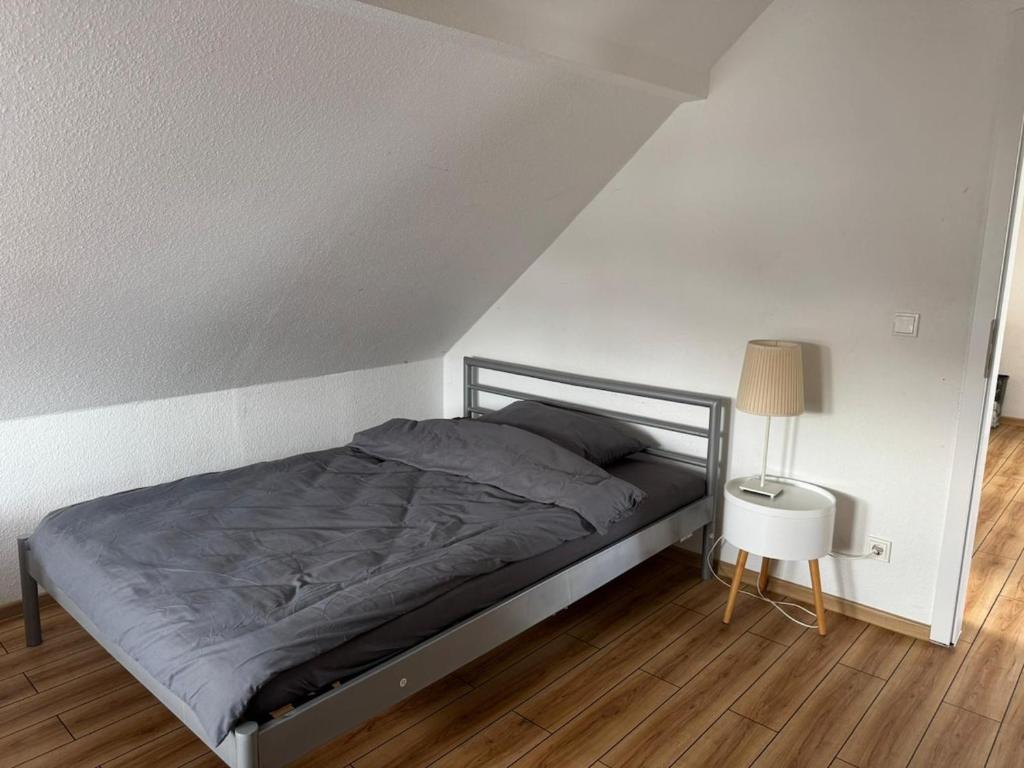 1 dormitorio con 1 cama y 1 lámpara en el suelo de madera en Monteurwohung, Wohnung Möbliert, 55543 Bad Kreuznach, en Bad Kreuznach