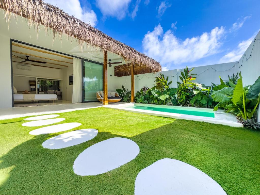 a garden with grass and stepping stones in a villa at Hoshi Villas in General Luna