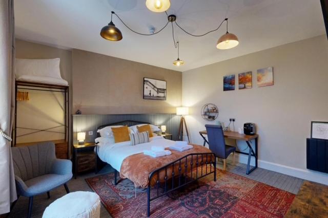 a bedroom with a bed and a chair and a desk at The Briery in Workington
