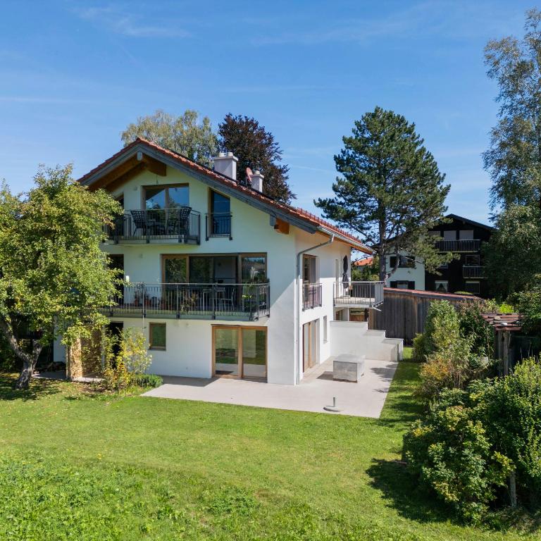 a large white house with a yard at BergSeeMomente in Breitbrunn am Chiemsee