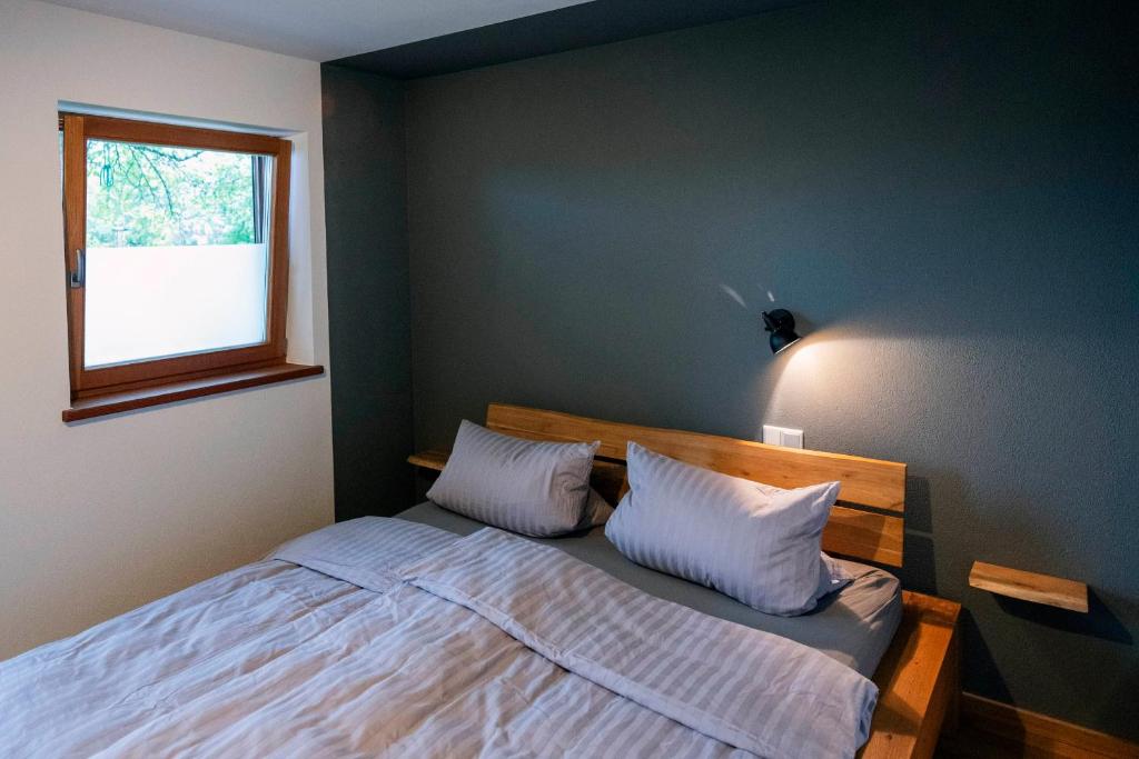 een slaapkamer met een bed met witte lakens en een raam bij BergSeeMomente in Breitbrunn am Chiemsee