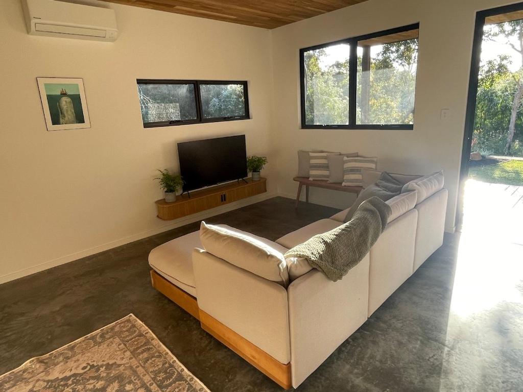 een woonkamer met een bank en een televisie bij Hafvilla Retreat in Margaret River Town