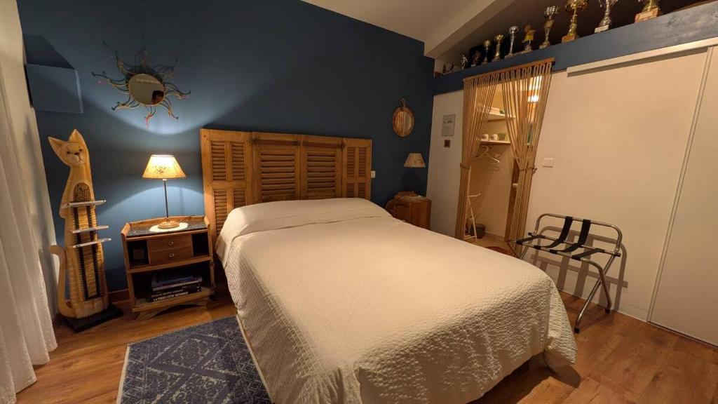 a bedroom with a white bed and a blue wall at La ruchette in Riez