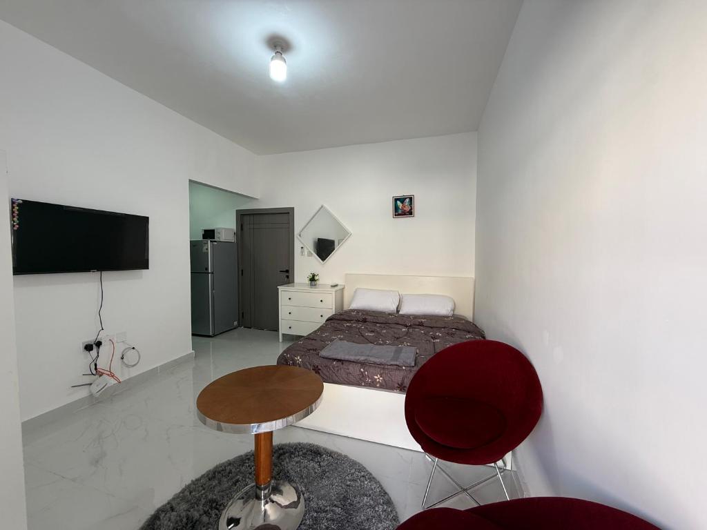 a bedroom with a bed and a table and chairs at Al Karama Studio in Abu Dhabi