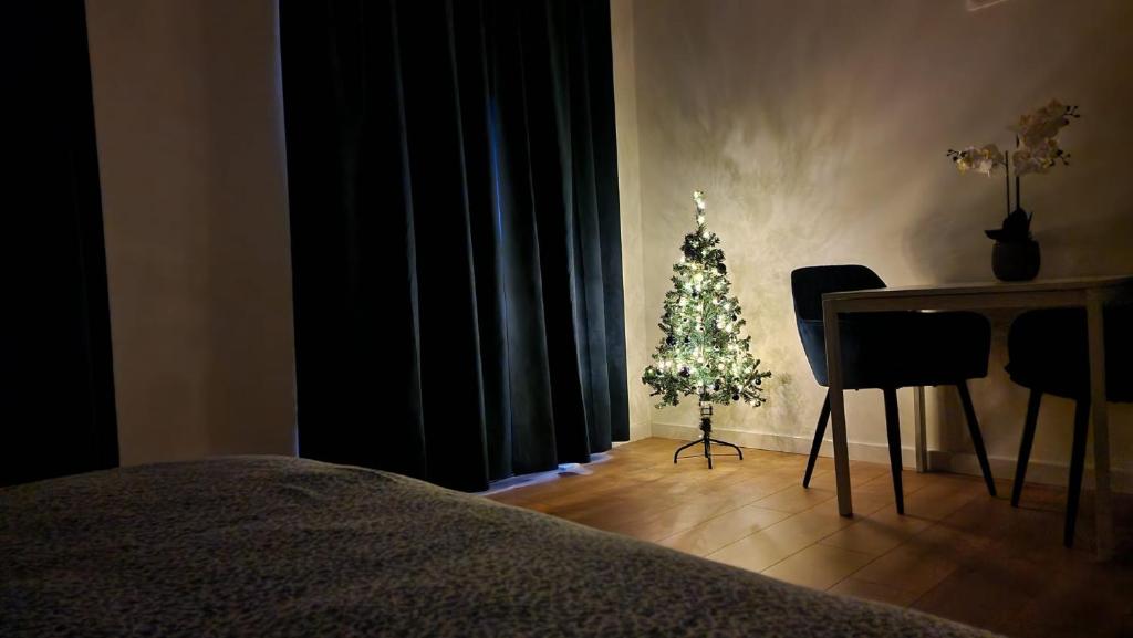 a christmas tree in a room with a table and a bed at Grote Markt suite 3 in Antwerp