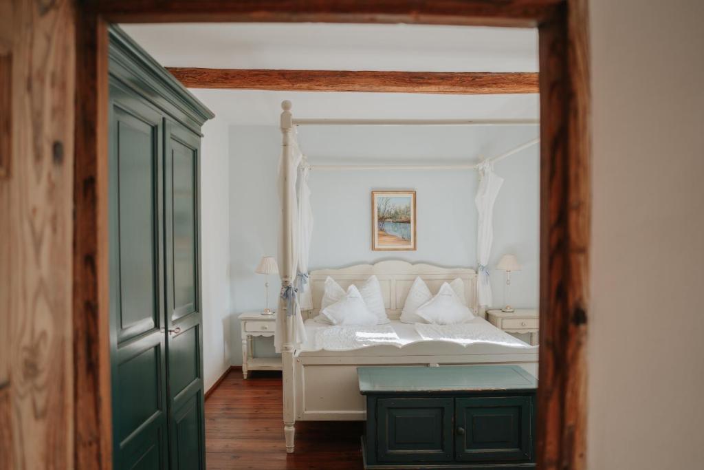a bedroom with a white bed and a green door at Ansitz Gurtenhof in Tesimo