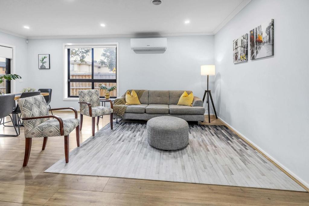 a living room with a couch and a table and chairs at Bright & Cozy 4-Bed Home in Rockbank in Rockbank