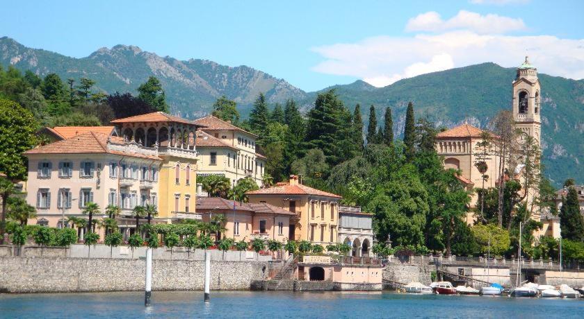 eine Gruppe von Gebäuden am Ufer eines Wasserkörpers in der Unterkunft Casa Victoria in Tremezzo