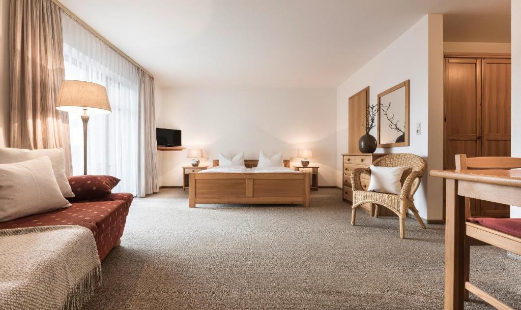 een woonkamer met een bank en een tafel bij Landhotel Rosenberger in Wegscheid