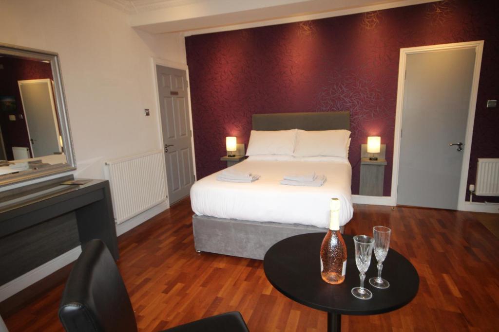 a bedroom with a bed and a table with glasses on it at Wollaton Park Hideaway in Nottingham