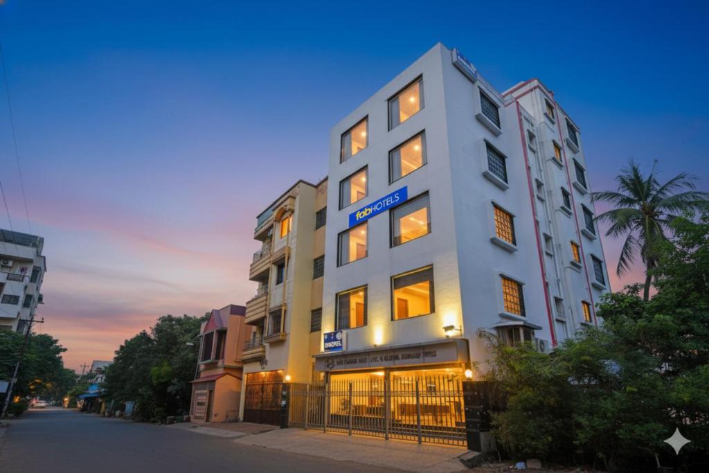 a tall white building on the side of a street at FabHotel AI Howrah in Kolkata