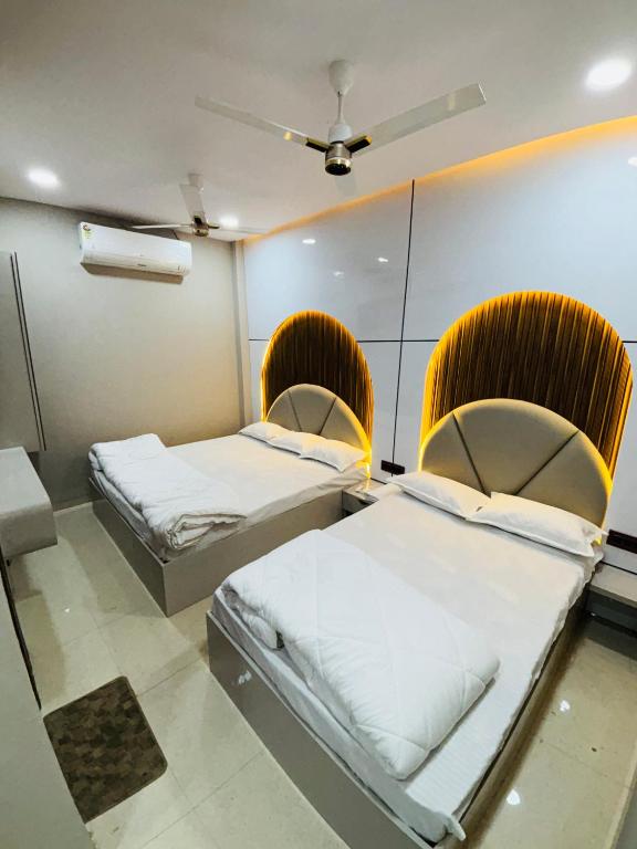 two beds in a room with mirrors at rk hotel in Ujjain