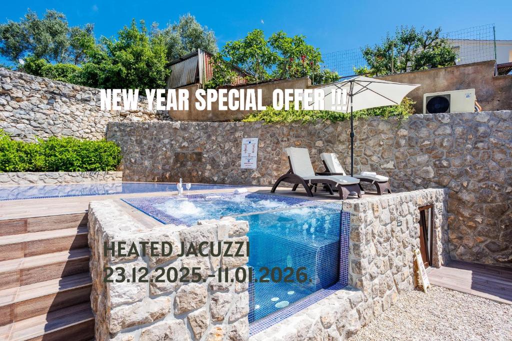 a swimming pool with two chairs and an umbrella at Villa Palma Krk in Krk