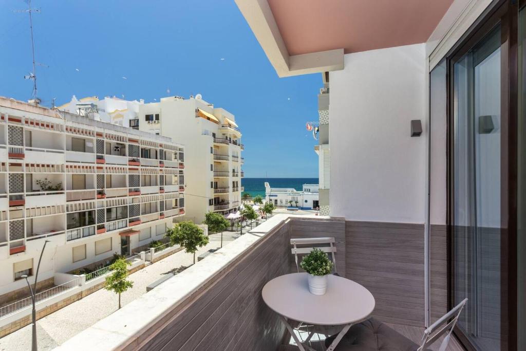 ein Balkon mit Tisch und Meerblick in der Unterkunft Luxury Beach Apartment at Armação de Pêra in Armação de Pêra