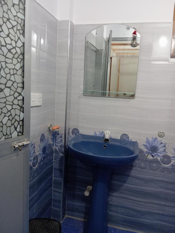 Un baño con un lavabo azul y un espejo. en mirissa niraj guest, en Mirissa