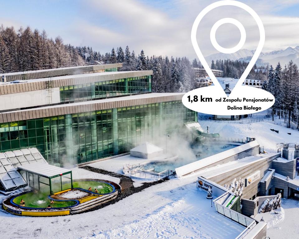 ein Gebäude mit einer heißen Quelle im Schnee in der Unterkunft Zespół Dolina Białego - Pensjonat Telimena in Zakopane
