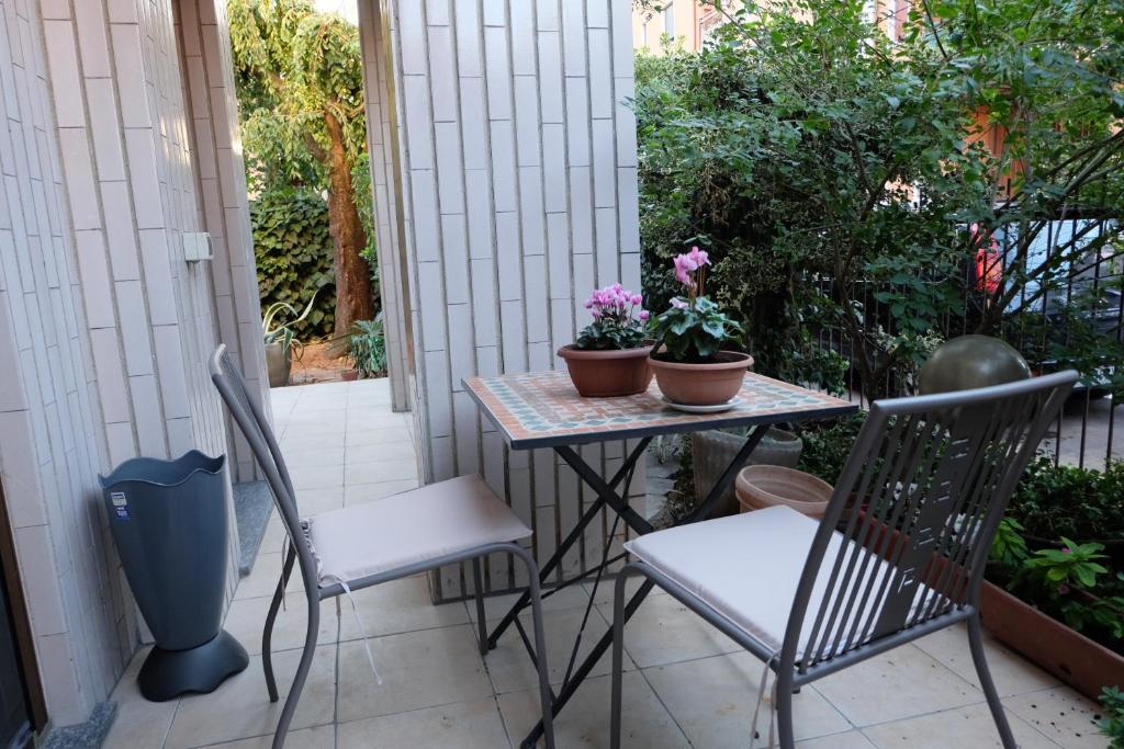 a table and chairs with flowers on a patio at Milano B&B in Cinisello Balsamo