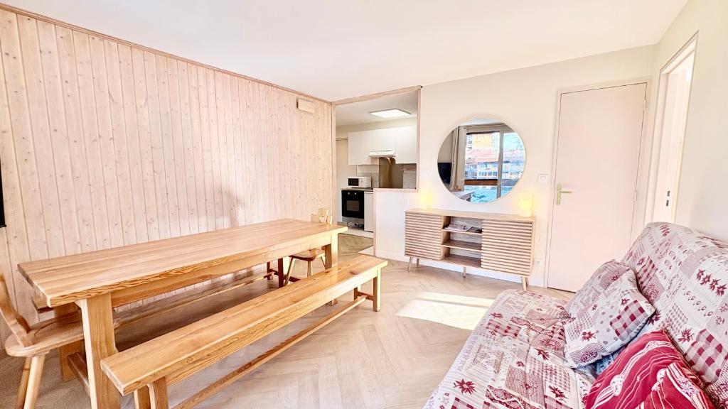 T3 Vanguard in front of ski school في Villarembert: غرفة معيشة مع طاولة وأريكة