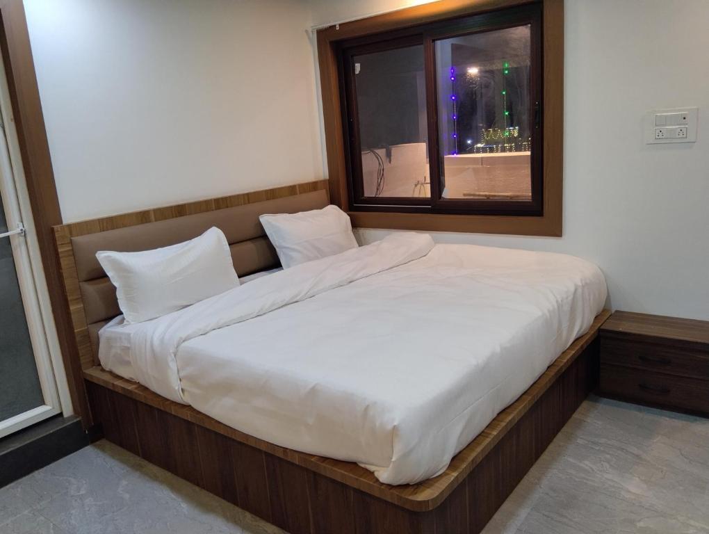 a bed in a room with a window at Hotel 7R RESIDENCY in Jhānsi