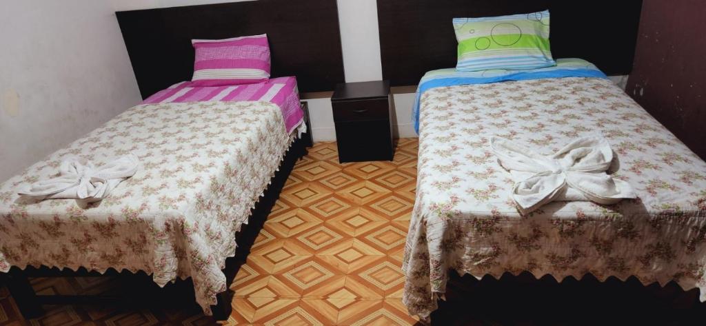 two beds sitting next to each other in a room at Hostal Bless Tacna in Tacna
