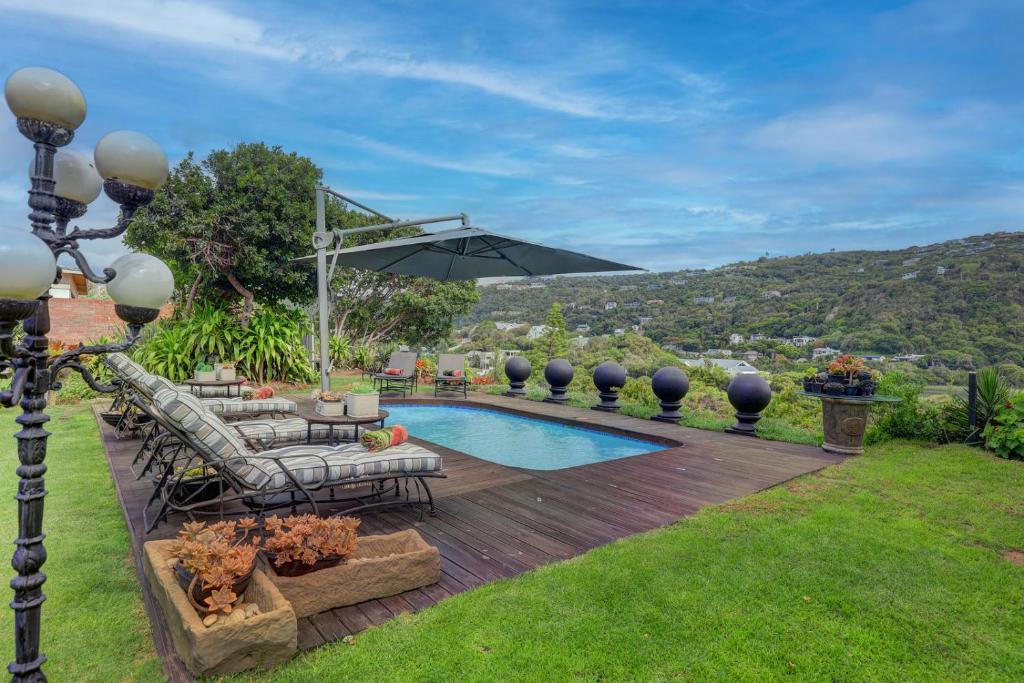 a backyard with a pool and a table and chairs and an umbrella at Stay Wilderness in Wilderness