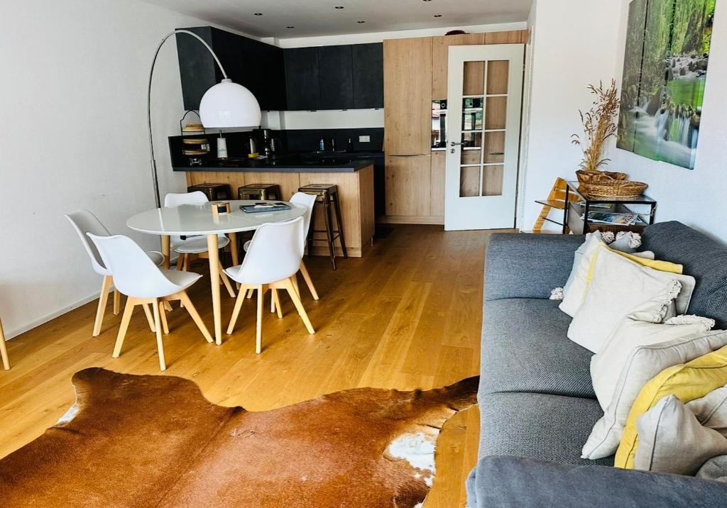 Apartment Schliersee - Stylisch, zentral, familienfreundlich في شليرزيه: غرفة معيشة مع أريكة وطاولة