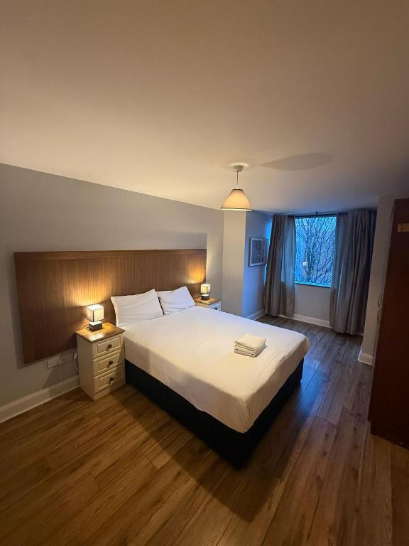 Two Bedroom Apartment Cork Road Killarney في كيلارني: غرفة نوم بسرير كبير ونافذة