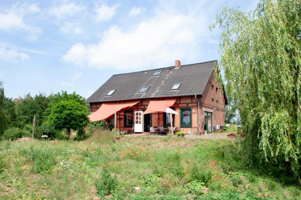 ein Haus mit schwarzem Dach auf einem Feld in der Unterkunft Elbenow in Losenrade