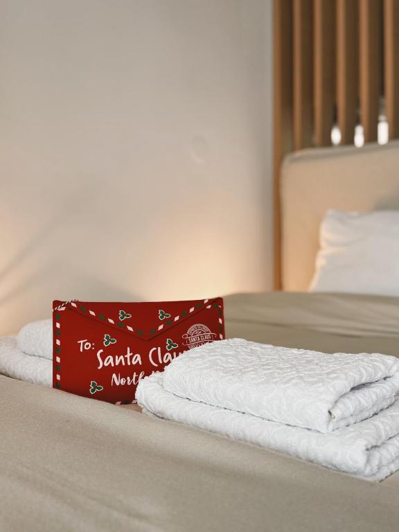 a bed with two towels and a red sign on it at Achinoeè in Chalkida
