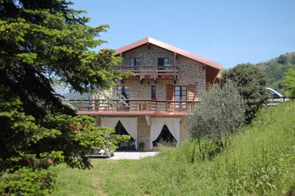 een groot bakstenen huis met een balkon op een heuvel bij Agriturismo I Due Angeli in Ome