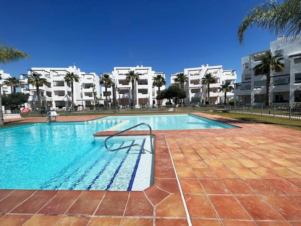 a swimming pool in front of some apartment buildings at Las Terrazas Golf Cédric in Torre-Pacheco