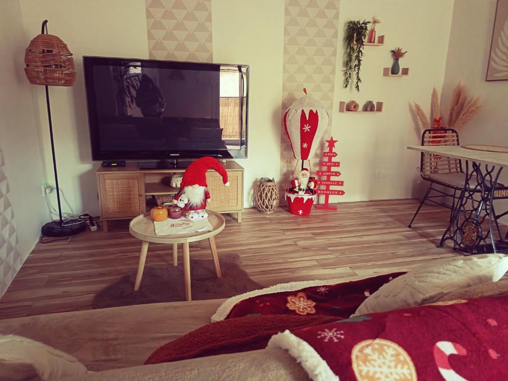 un soggiorno con TV a schermo piatto e tavolo di La Casaflo a Florensac