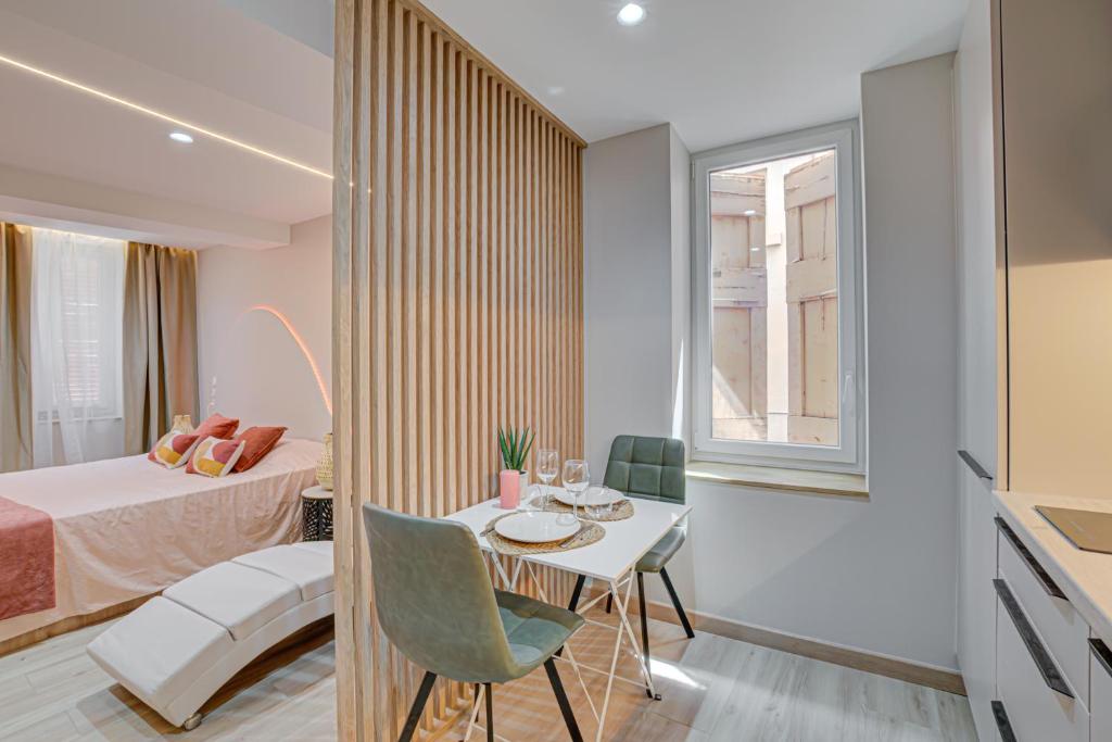 a small room with a table and a bed at Serenity Suite in Bourgoin