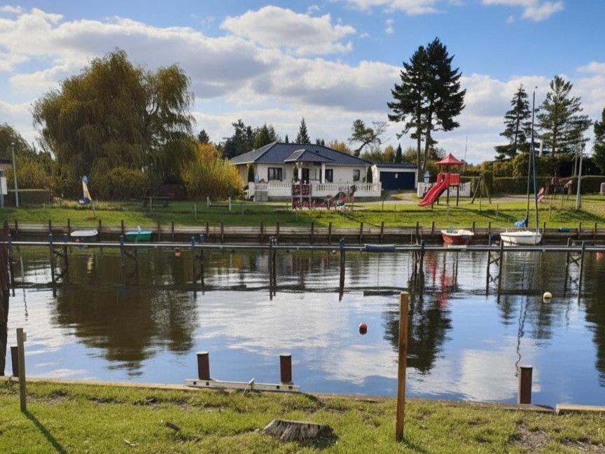 a body of water with a house in the background at Ferienhaus Alla, Neeberg/Usedom in Neeberg