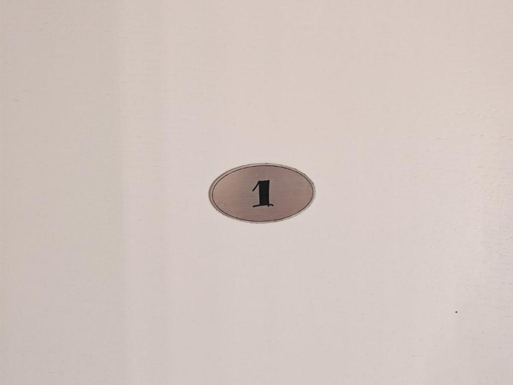 a clock on a wall with the number one on it at KONDOR apartmani in Vrnjačka Banja