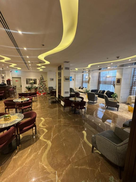 a lobby with a christmas tree and tables and chairs at Reggenza Hotel Downtown Ramallah in Ramallah