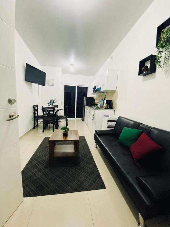 uma sala de estar com um sofá preto e uma mesa em VillaOriental em San Miguel