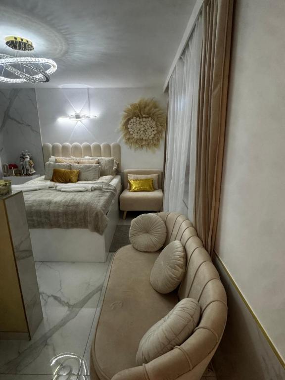 a bedroom with a bed and a tufted couch at GOLD apartment in Święta Katarzyna