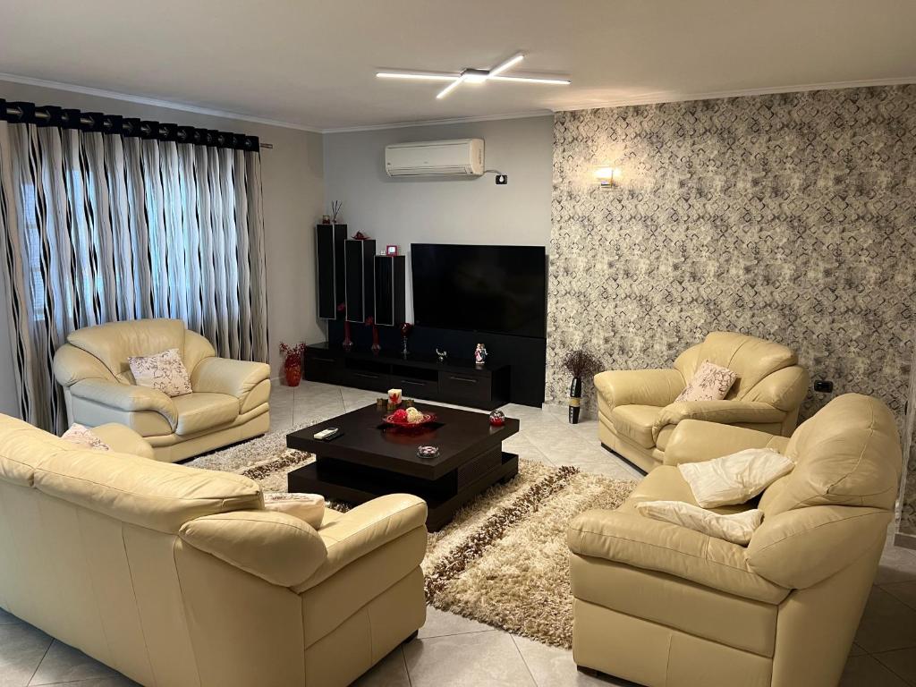 a living room with couches and a flat screen tv at Manga Luxury Apartments - 2 Bedrooms in Gjirokastër