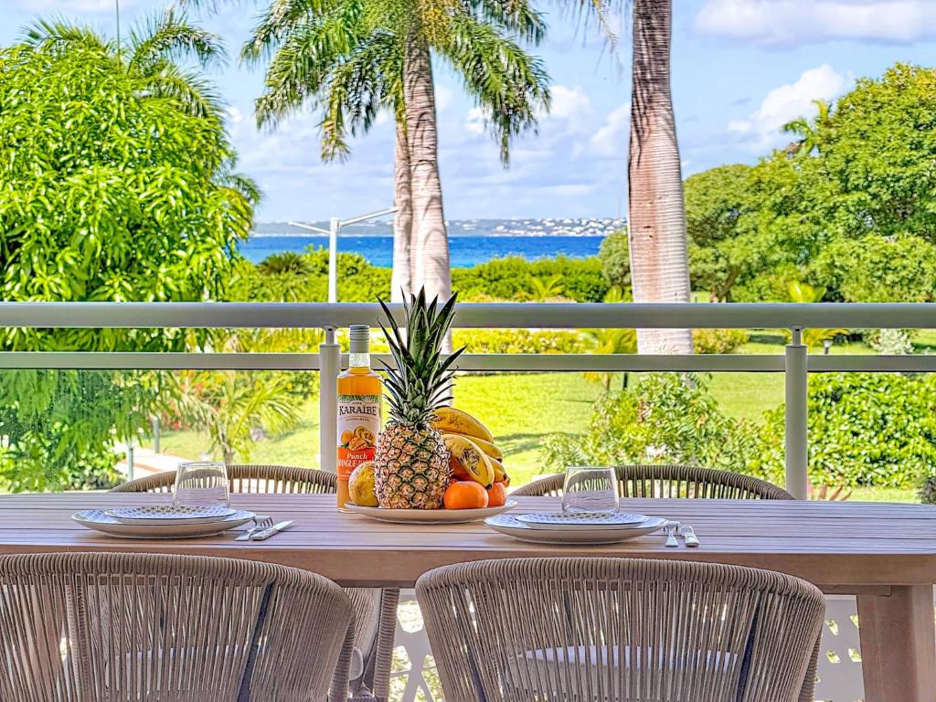 una mesa con un bol de fruta en ella en Case à Sucre Peaceful retreat with sea view and beach direct access, en Anse Marcel 