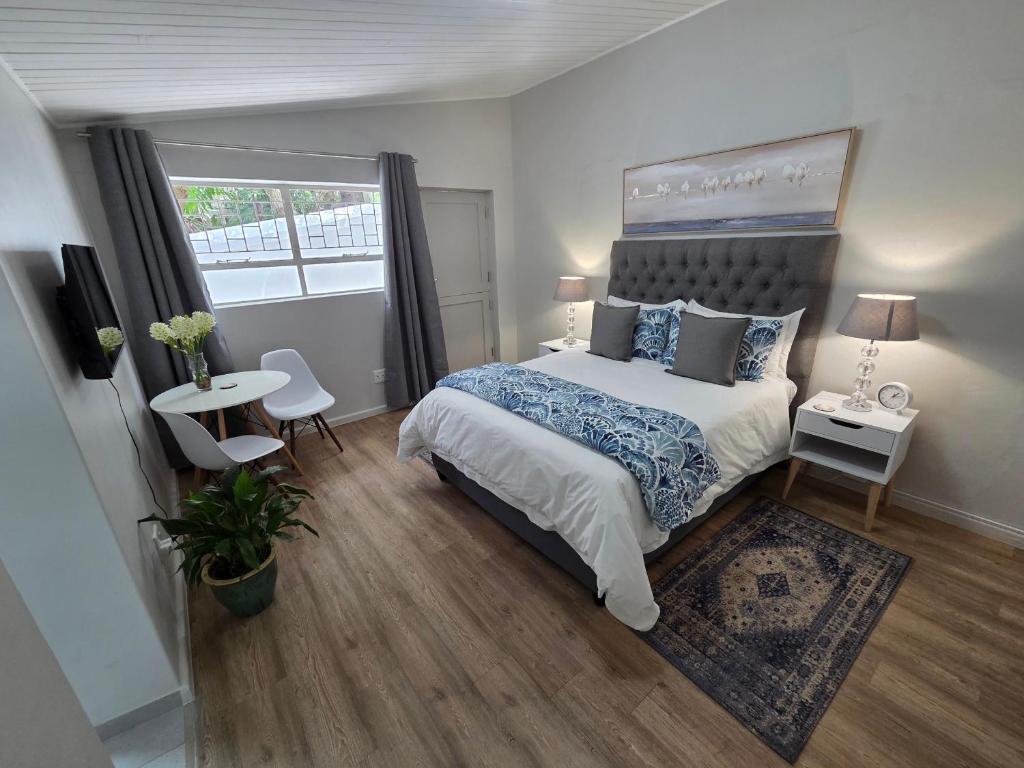 Un dormitorio con una cama grande y una ventana. en SleepINN at Dumont, en Paarl