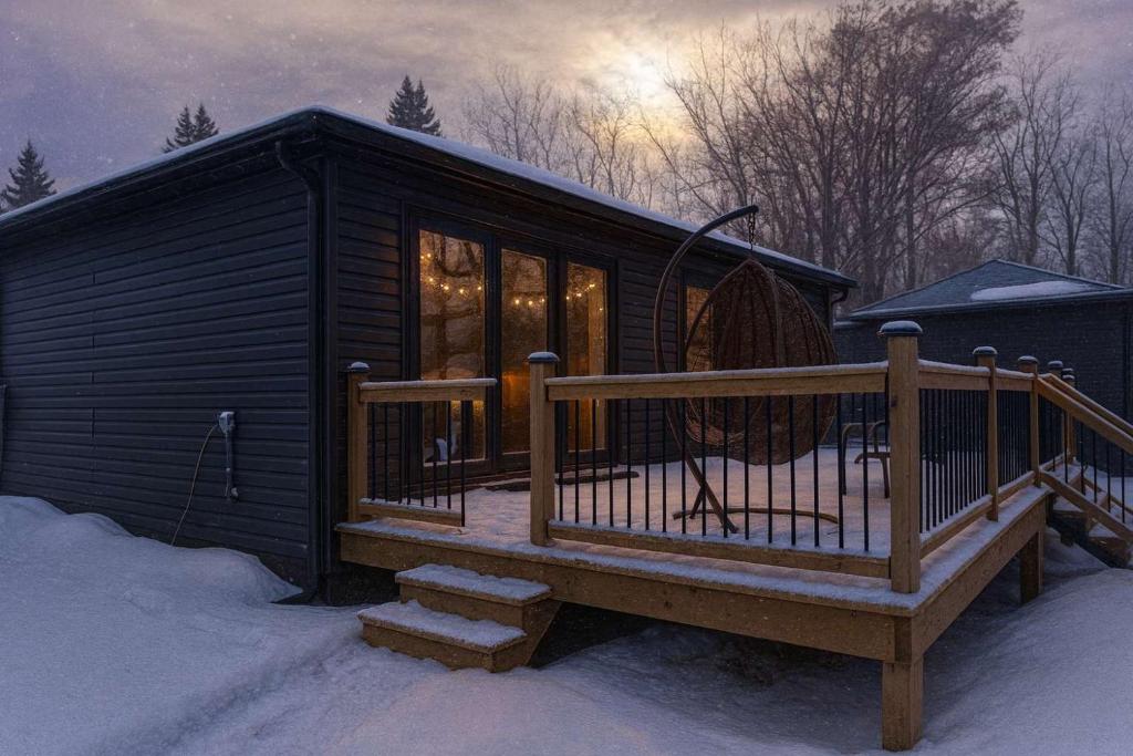 a cabin with a deck in the snow at 2-bedroom Lake Front Cottage in Harwood ON #2 in Harwood