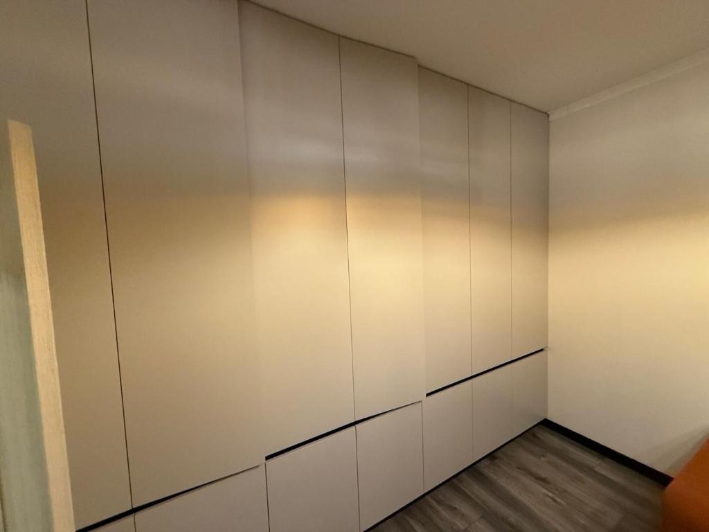 an empty locker room with white walls and wooden floors at Apartament for Guest in Jelgava