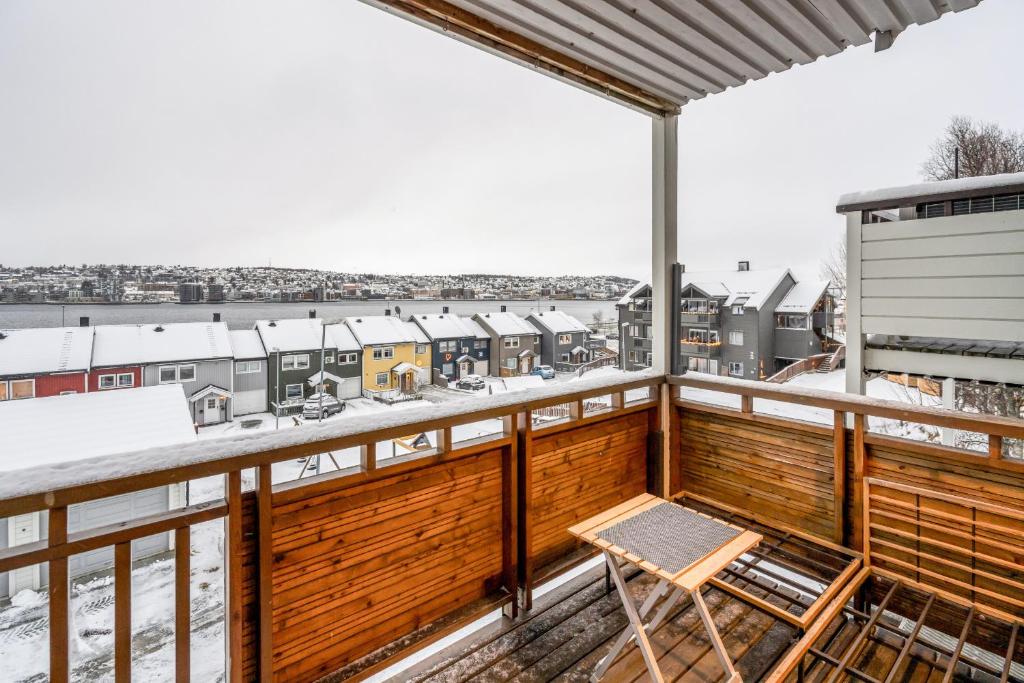 a balcony with a wooden railing and a chair at Apartment with view of the city in Hjorten