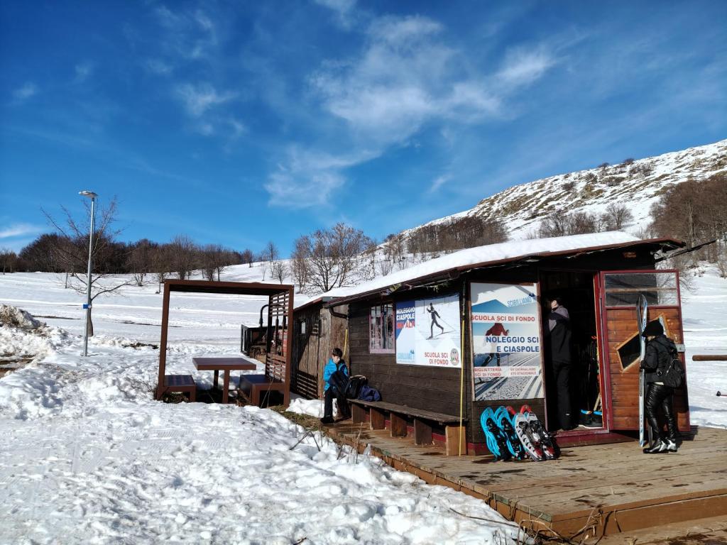 菲亚斯特拉Maison en Pierre的站在建筑物外的雪中的人